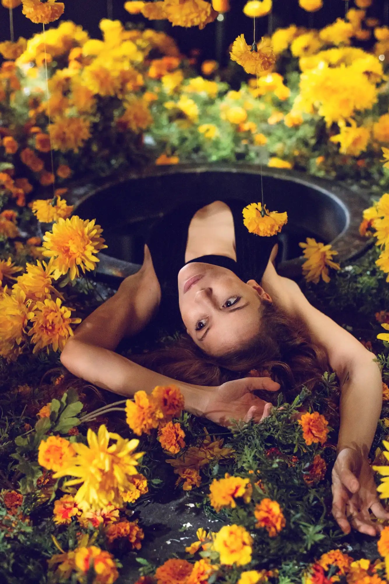 Woman surrounded by yellow flowers.